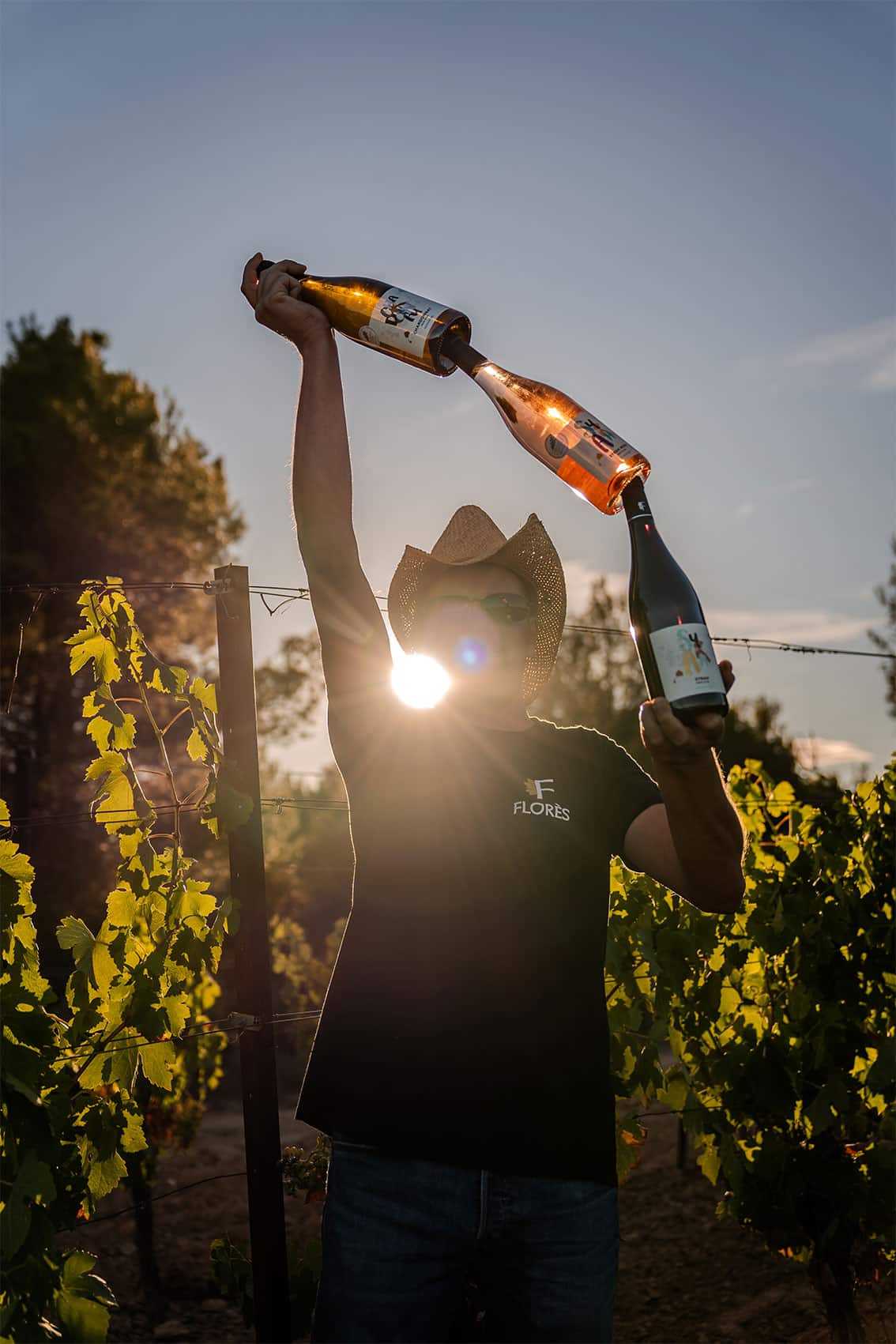 Photo prise par le photographe professionnel Les insensés représentant un vigneron Pays d'Oc IGP dans les vignes avec des bouteilles de vin