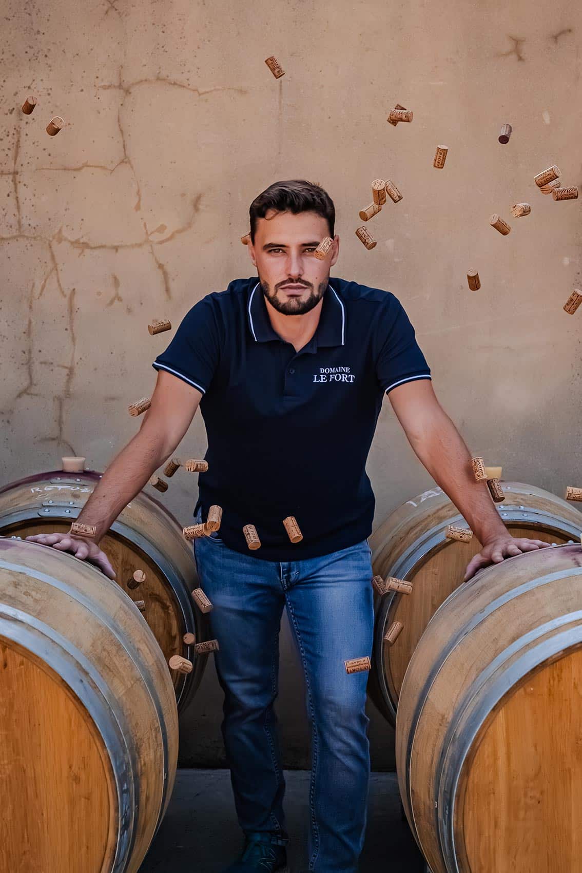 Photo portrait shootée par le photographe professionnel Les insensés représentant un vigneron Pays d'Oc IGP appuyé sur des cuves de vin