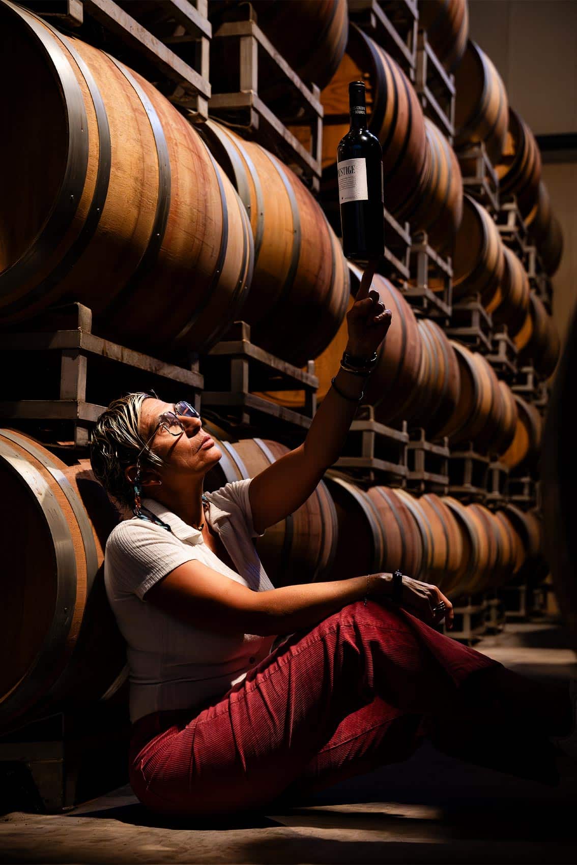 Photo shootée par le photographe professionnel Les insensés représentant une vigneronne Pays d'Oc IGP dans des cuves avec une bouteille de vin