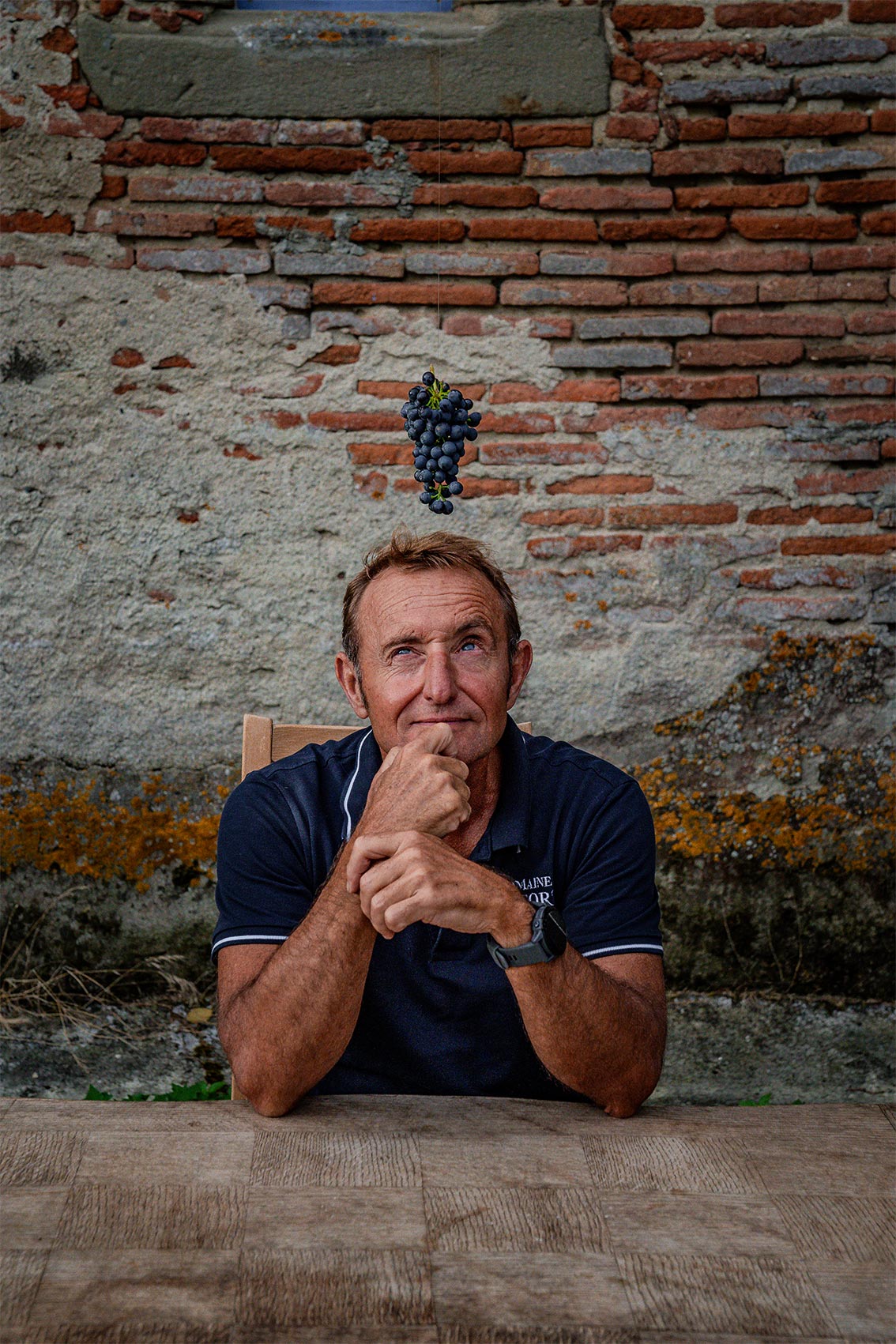 Photo portrait réalisée par le photographe professionnel Les insensés représentant vigneron Pays d'Oc IGP jouant avec une grappe de raisin